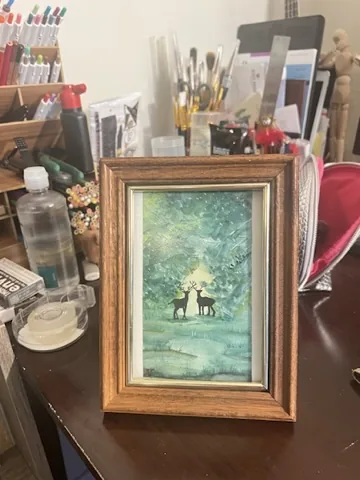 Framed watercolor of deer in a forest
